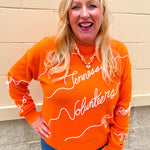 Orange merino wool blend Tennessee Volunteers script sweater featuring chain stitch embroidered hand-drawn collegiate artwork.