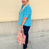 Light pink pleated top with puff sleeves and back tie details, styled for a breezy, feminine look.