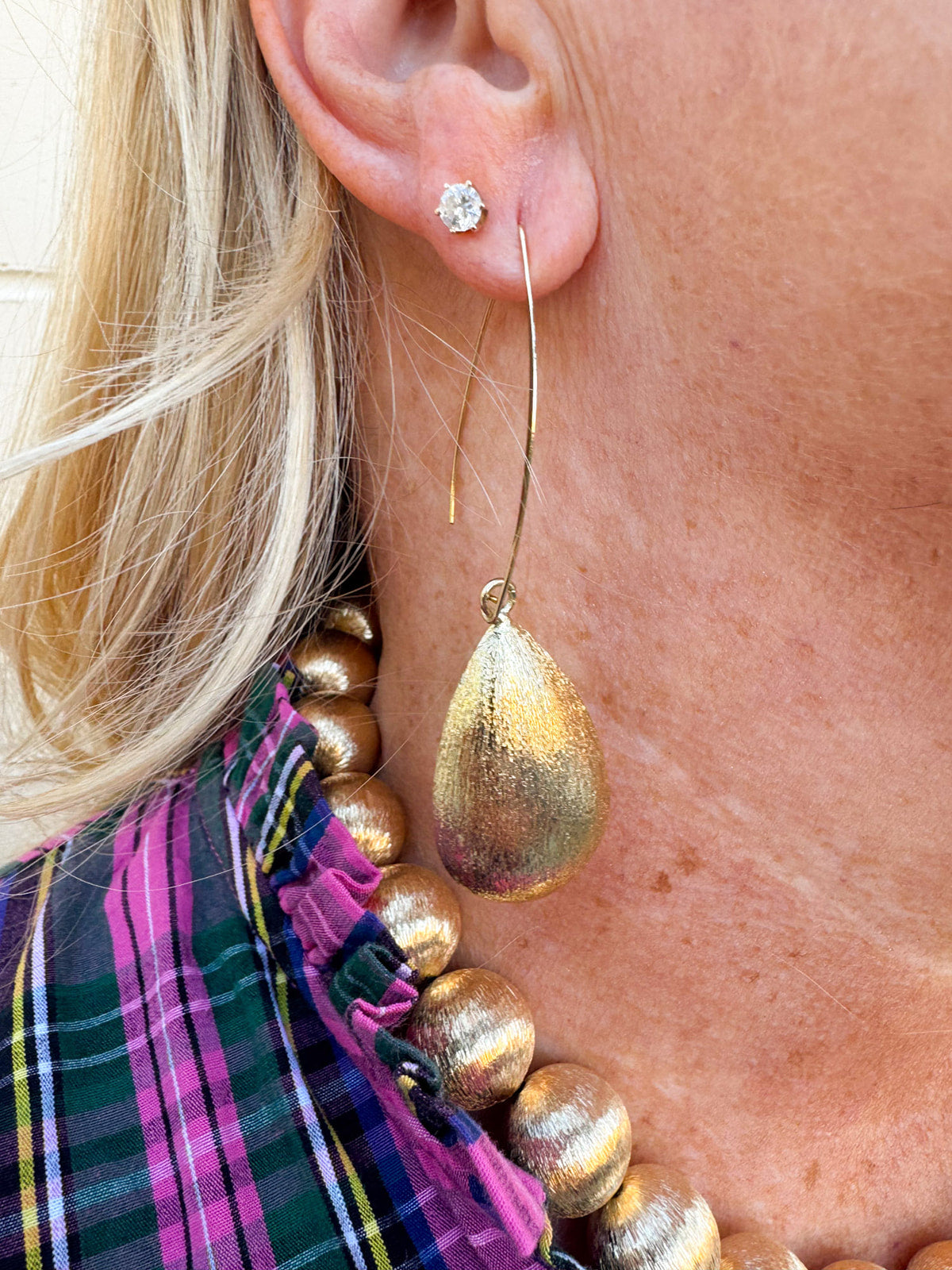 Large gold textured teardrop drop hoop earrings with threader-style studs.