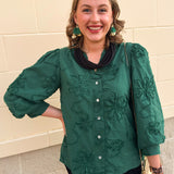 Hunter green 3D floral top with ruffled neckline, button-down front, and ¾-length puff sleeves.