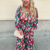 A feminine midi dress with ruffled neckline, long sleeves, and abstract floral print in red, pink, and green.