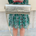 Gold metallic woven-texture crossbody bag with detachable strap and structured design.