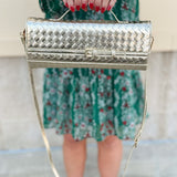 Gold metallic woven-texture crossbody bag with detachable strap and structured design.