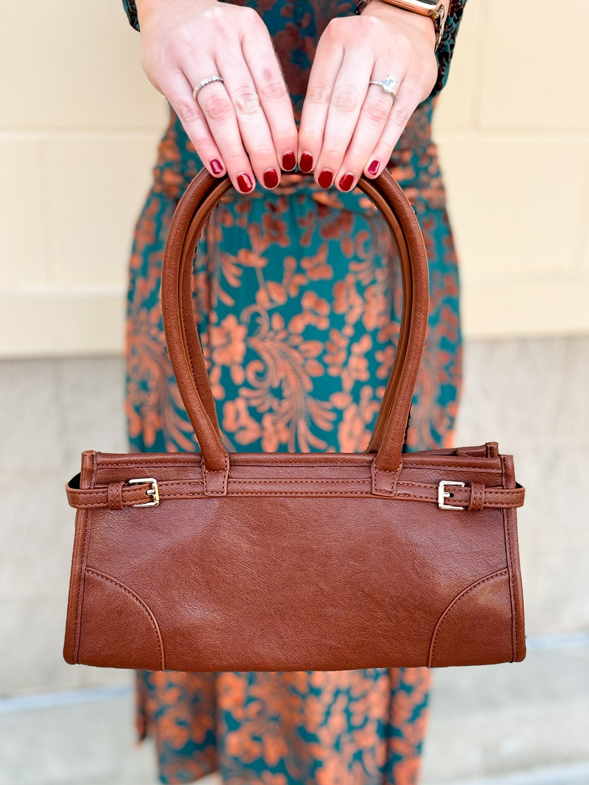 Brown structured vegan leather crossbody bag with gold hardware and top handles.