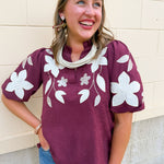 Wine faux suede top with short puff sleeves, ruffle neckline, and floral embroidery