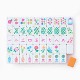 Colorful acrylic mahjong tiles in coral, orange, and neon pink arranged on a tabletop