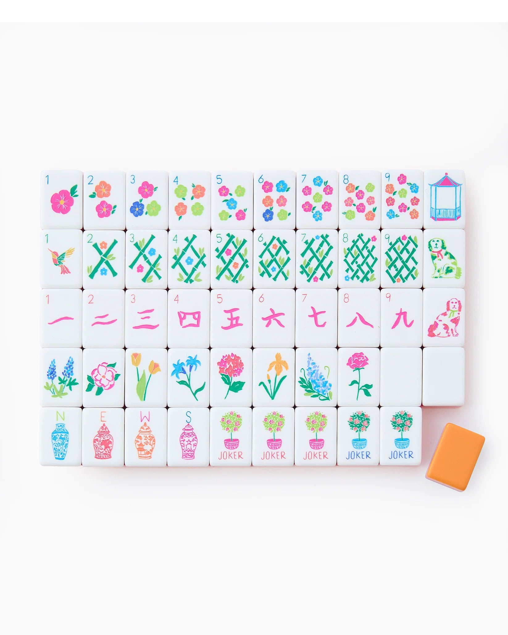Colorful acrylic mahjong tiles in coral, orange, and neon pink arranged on a tabletop