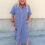 Navy and white striped maxi dress with collared neckline, full button front, cuffed sleeves, and flowing silhouette.