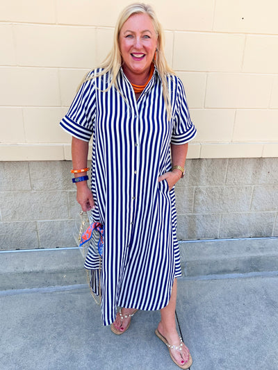 Navy and white striped maxi dress with collared neckline, full button front, cuffed sleeves, and flowing silhouette.