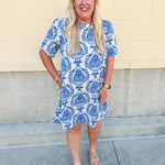 Blue and white damask print short-sleeve mini dress with pockets and back zipper closure, styled for a casual yet polished look.
