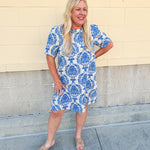 Blue and white damask print short-sleeve mini dress with pockets and back zipper closure, styled for a casual yet polished look.