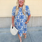 Blue and white damask print short-sleeve mini dress with pockets and back zipper closure, styled for a casual yet polished look.