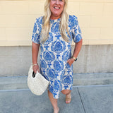 Blue and white damask print short-sleeve mini dress with pockets and back zipper closure, styled for a casual yet polished look.