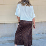 White long-sleeve knit sweater with contrasting brown buttons