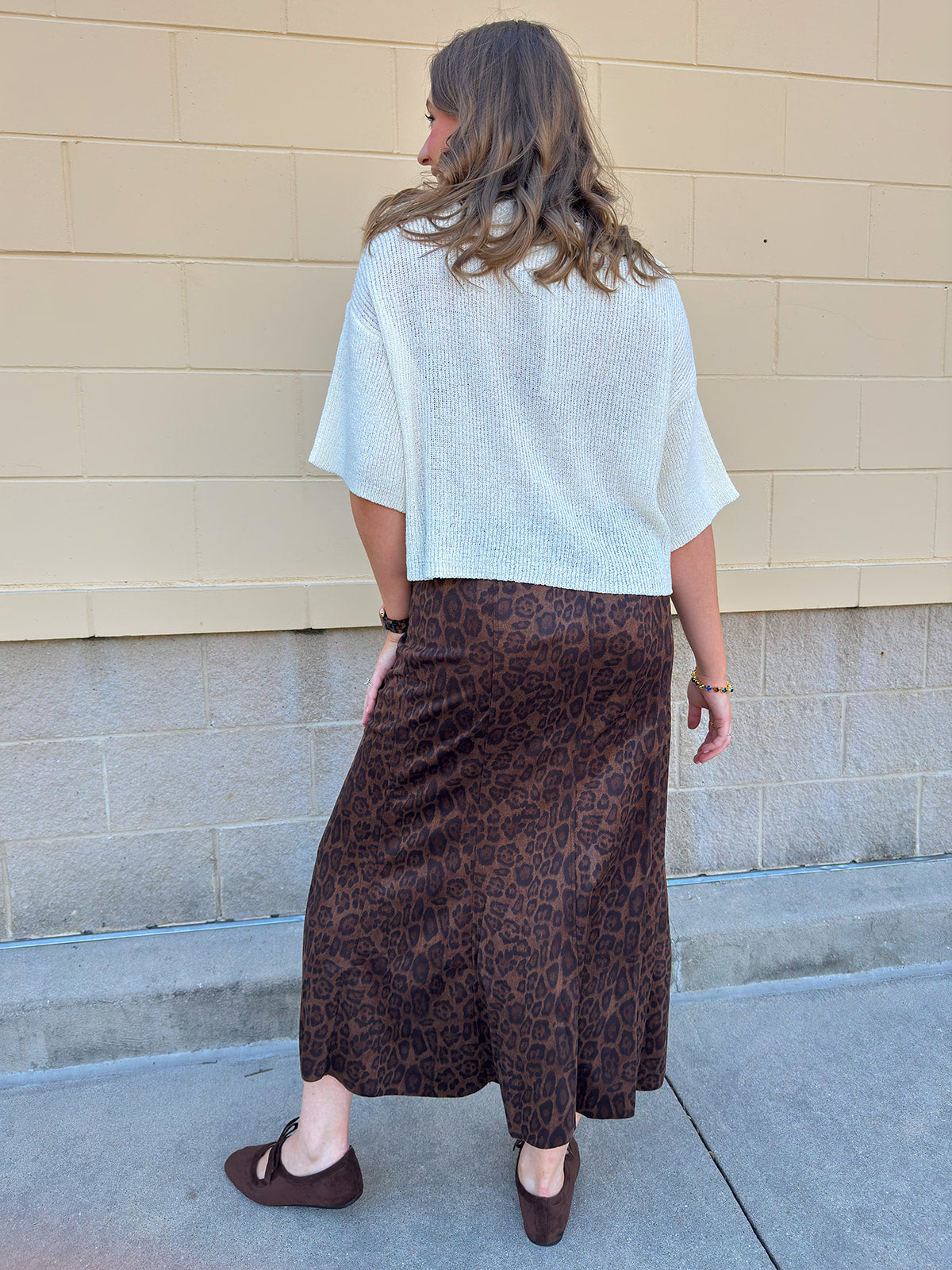 White long-sleeve knit sweater with contrasting brown buttons