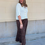 White long-sleeve knit sweater with contrasting brown buttons