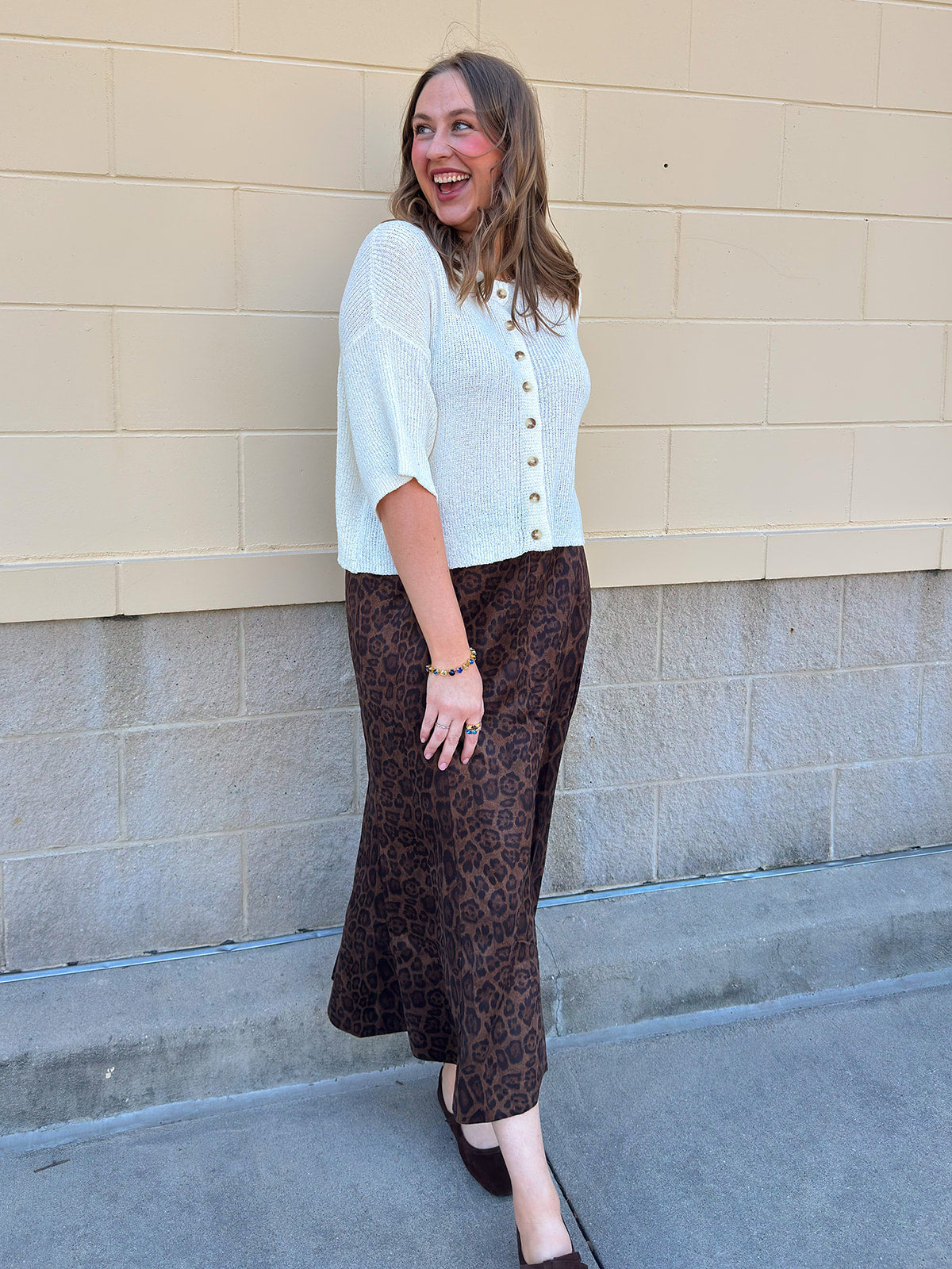 White long-sleeve knit sweater with contrasting brown buttons