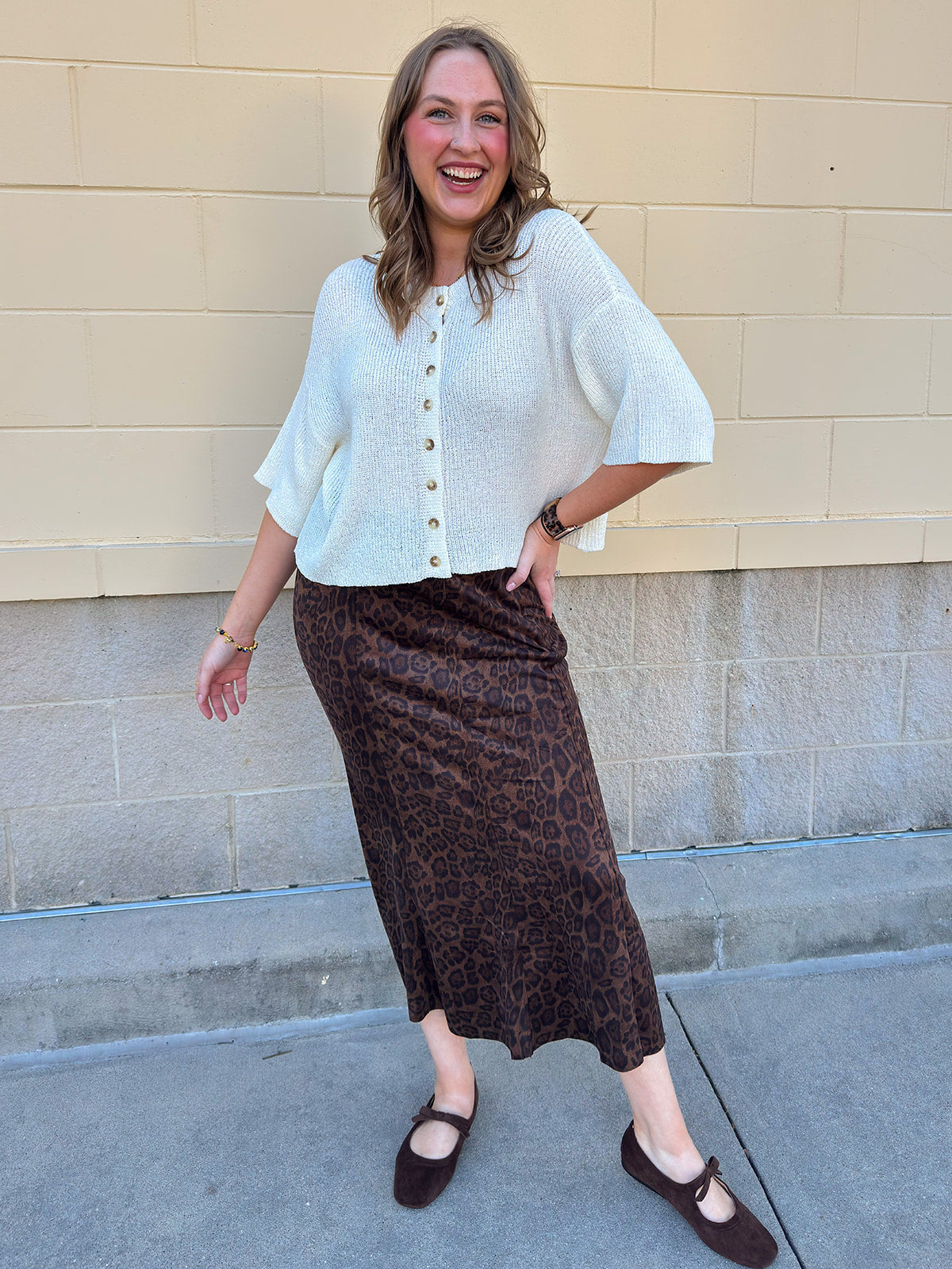 White long-sleeve knit sweater with contrasting brown buttons