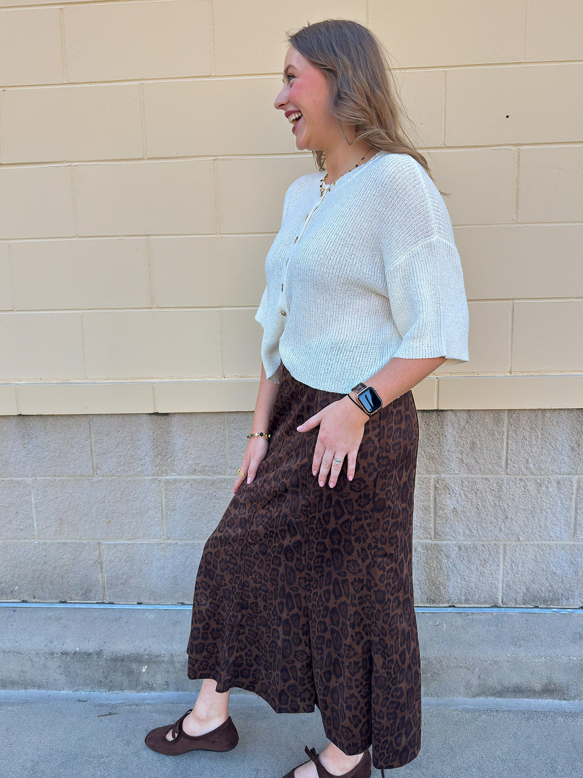 White long-sleeve knit sweater with contrasting brown buttons