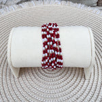 A 12-layer beaded bracelet stack with garnet, white, and gold beads, styled for fall and gameday wear.