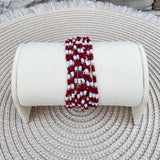 A 12-layer beaded bracelet stack with garnet, white, and gold beads, styled for fall and gameday wear.