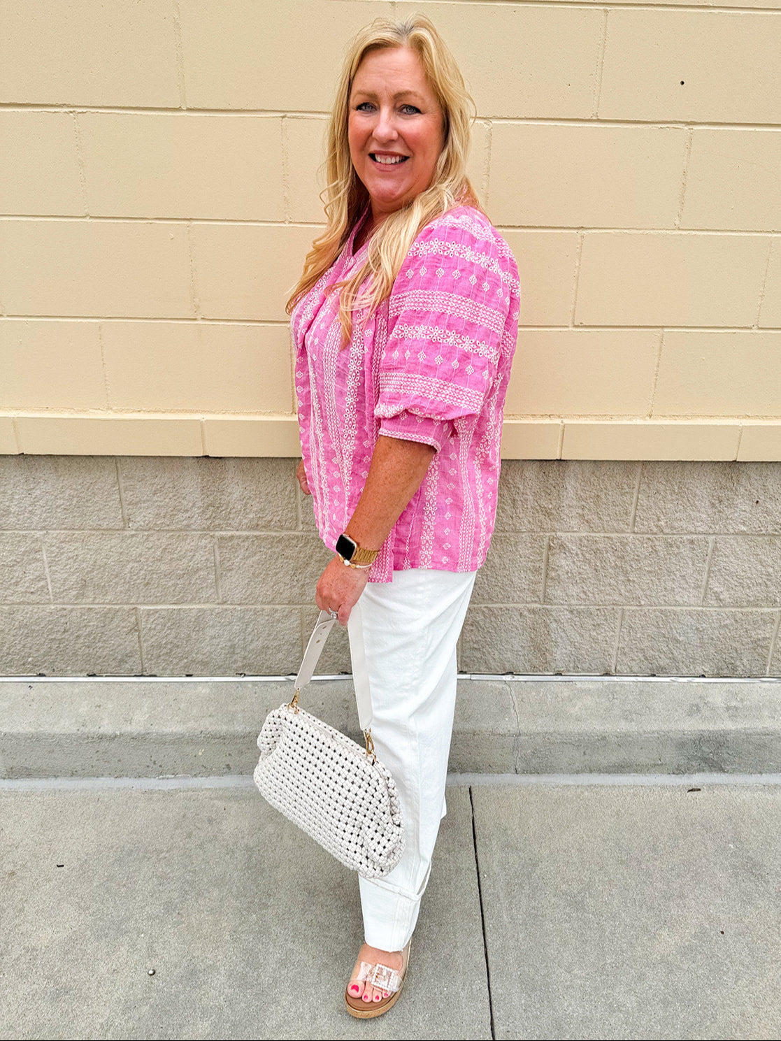Pink cotton top with cream floral embroidery, ruffled v-neckline, and puff sleeves