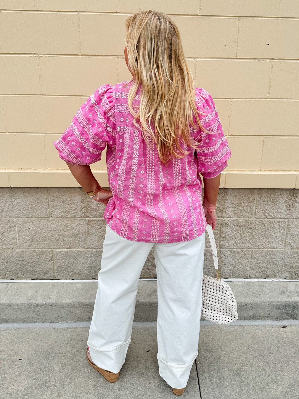 Pink cotton top with cream floral embroidery, ruffled v-neckline, and puff sleeves