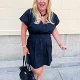 Black poplin mini dress with a V-neckline, button-front closure, short sleeves, and a smocked back waist.