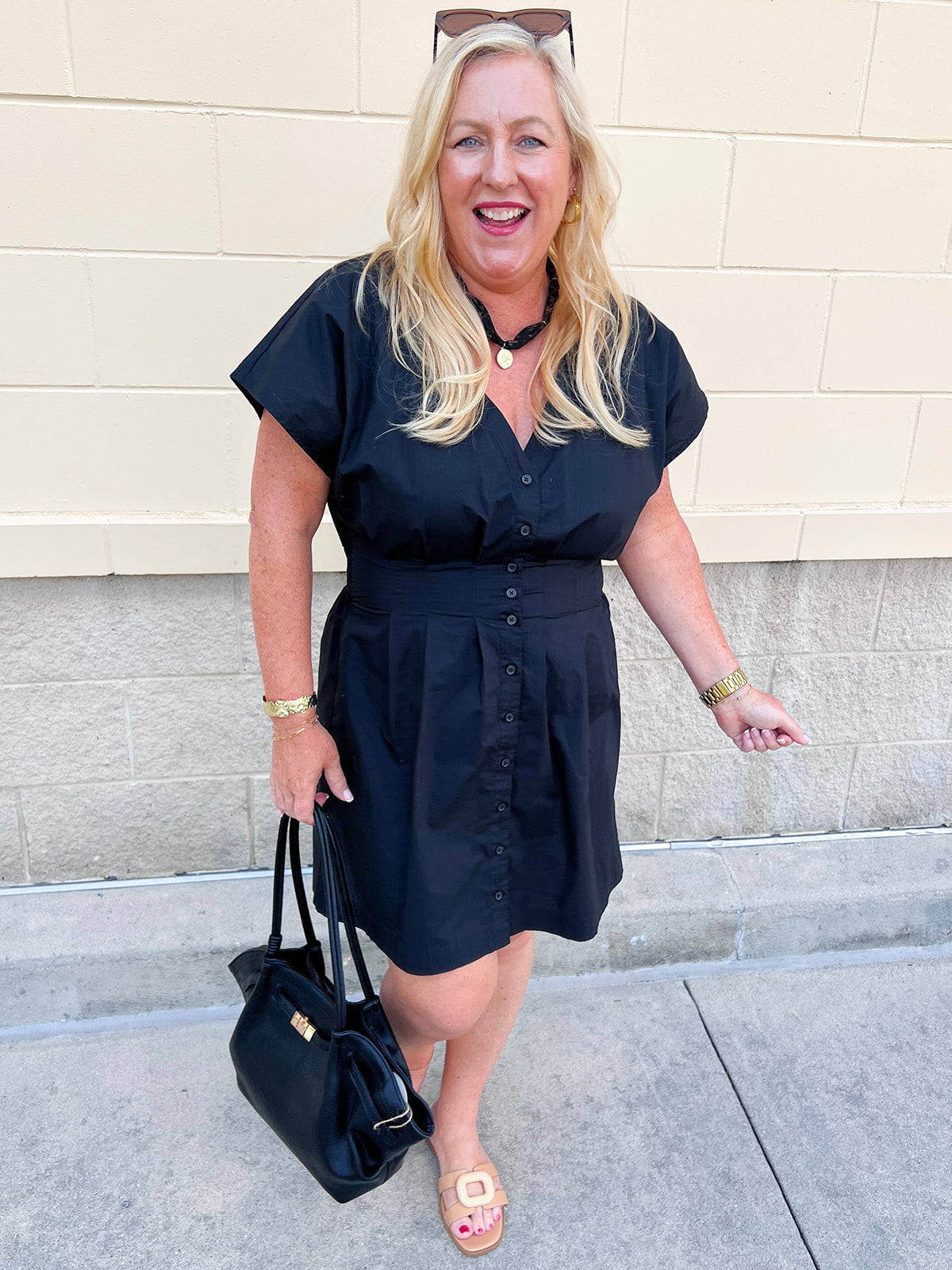 Black poplin mini dress with a V-neckline, button-front closure, short sleeves, and a smocked back waist.
