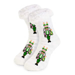 Soft slipper socks with pink and green nutcracker design holding champagne bottles, fluffy cuff, and grip bottoms.