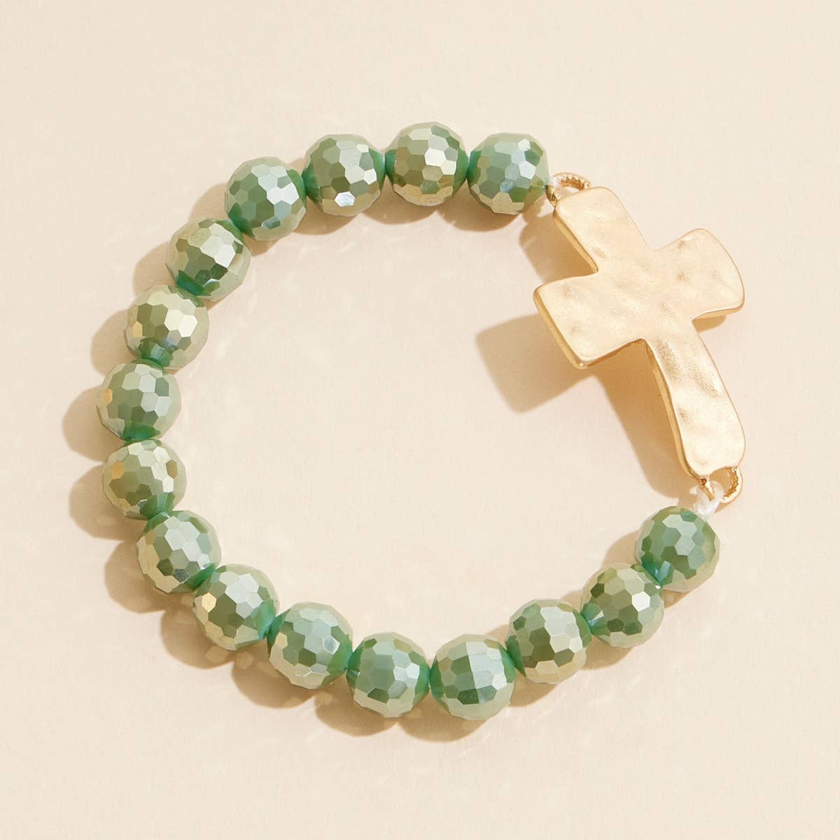 Olive green glass beaded stretch bracelet with hammered metal cross charm.