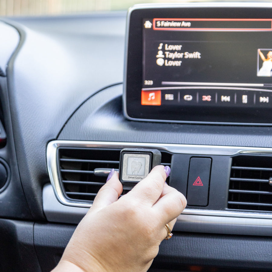 Compact car vent clip styled in a vehicle interior with neutral tones