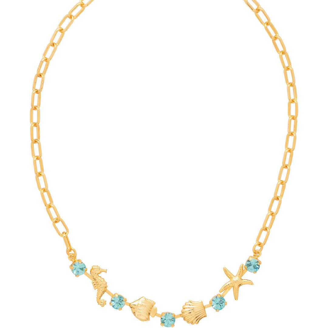 Necklace with alternating crystals and sea-themed charms on an adjustable chain.