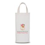 White fabric wine bag with Santa head in pink hat and text reading “He Sees You When You’re Drinking.”