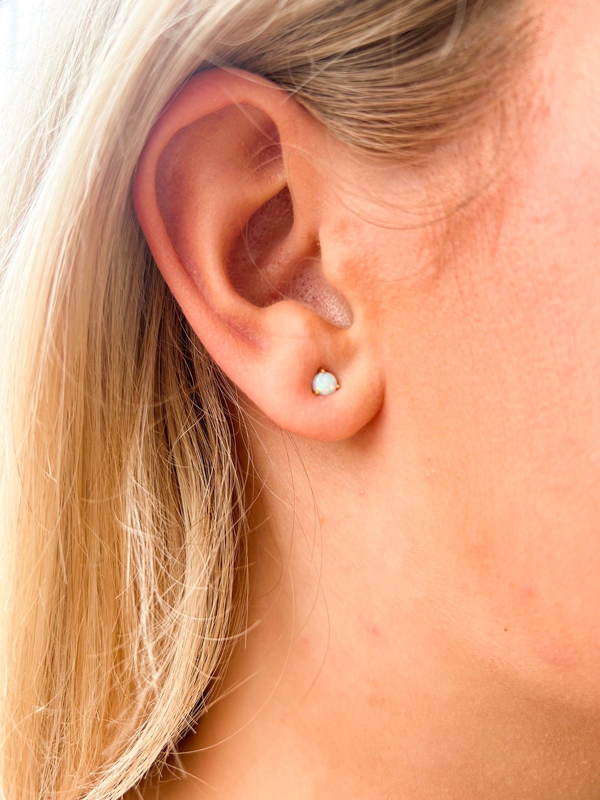 Gold stud earrings with iridescent opal stones