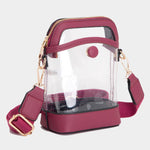 Garnet-trimmed clear stadium bag with zipper closure, top handle, and adjustable crossbody strap.
