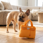 Bright orange plush handbag-shaped dog toy with a built-in squeaker.