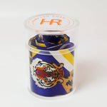 Scarf with tiger design in a clear container on a white background