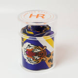Scarf with tiger design in a clear container on a white background