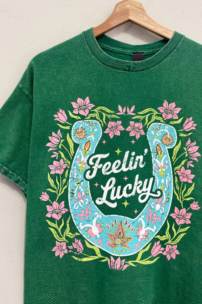 Green short sleeve graphic t-shirt with horseshoe design and “Feelin’ Lucky” text on the front with a relaxed casual fit.