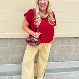 Clear football-shaped crossbody bag with garnet trim, zipper closure, and adjustable straps.