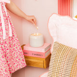 Iridescent pearl-toned candle with a ribbed surface and dual wicks, styled as elegant home décor