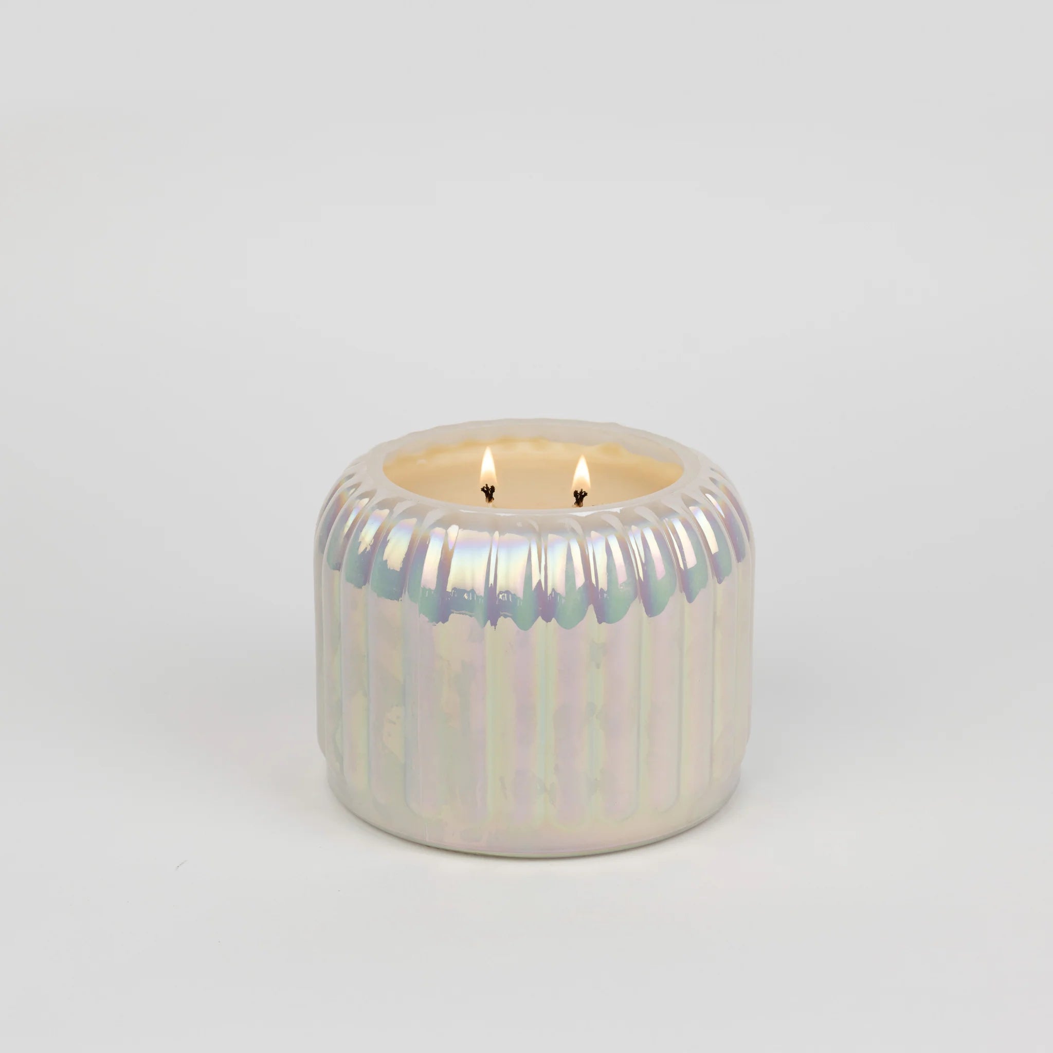 Iridescent pearl-toned candle with a ribbed surface and dual wicks, styled as elegant home décor