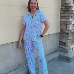 Nutcracker Charm Pajama Set with a short-sleeve collared shirt and long pants featuring nutcrackers, Christmas trees, and holiday details in white, light green, and light pink