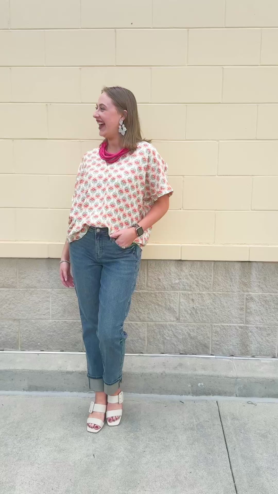 Bright floral v-neck top with dolman sleeves and drop shoulder design, styled for a relaxed and feminine look.