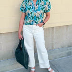 Blue floral blouse with pink accents, featuring a ruffle-trimmed split neckline and short puff sleeves