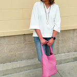 White blouse with ruffled V-neck and ¾ length wide sleeves, styled for a feminine, polished look.