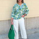 Loose-fit blouse with V-neckline and 3/4 sleeves in a pink, orange, and purple floral tie-dye print, styled for an effortless, vibrant look.