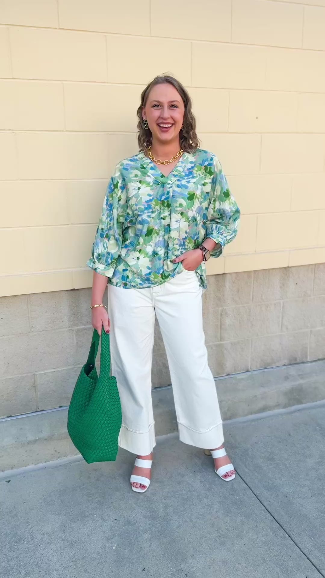 Loose-fit blouse with V-neckline and 3/4 sleeves in a pink, orange, and purple floral tie-dye print, styled for an effortless, vibrant look.
