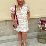 Cream mini dress with taupe geometric eyelet pattern, puffed sleeves, open collar, and side pockets